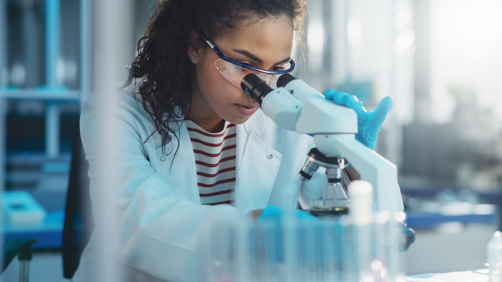 2148_Scientist looking under microscope in medical science laboratory