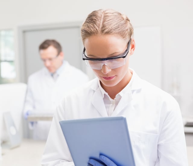 3242_Scientist using tablet while colleagues working behind_Cropped