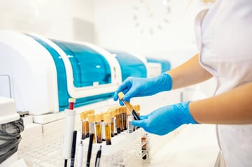 card-3223_Nurse standing in a laboratory and taking test tubes with blood samples