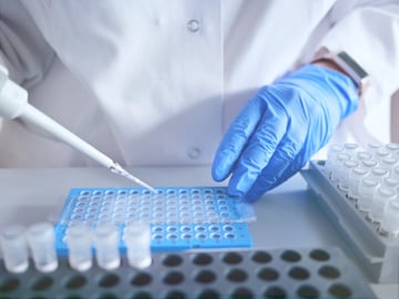 card-3233_Laboratory scientist working at lab with micropipette, and 96 well plate