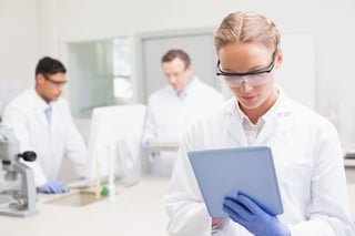 card-3242_Scientist using tablet while colleagues working behind