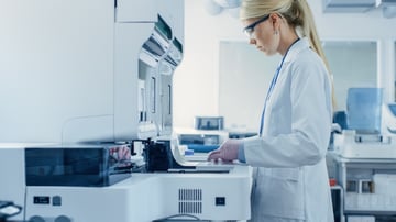 card-3255_Female Research Scientist Putting Test Tubes with Blood Samples into Analyzer