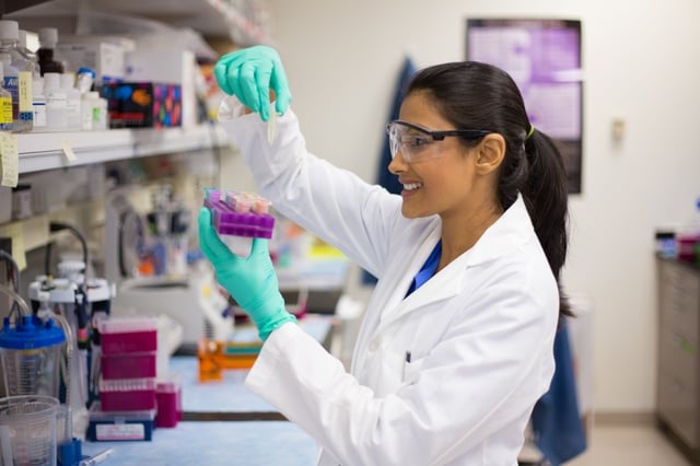 card-3272_scientist in labcoat wearing nitrile gloves, doing experiments in lab