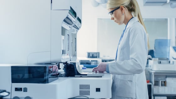 3255_Female Research Scientist Putting Test Tubes with Blood Samples into Analyzer