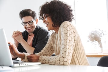 website-featured_jpg-2213_cheerful-young-colleagues-using-laptop